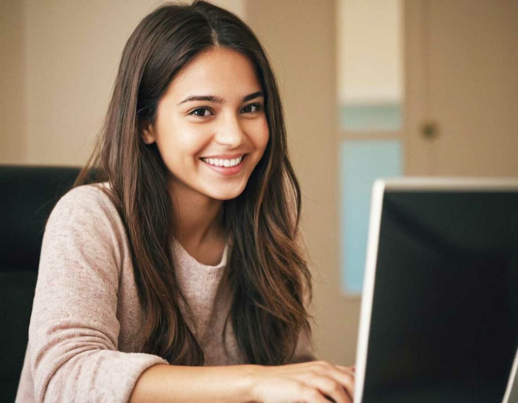 Ragazza con DSA che usa un computer con software di scrittura predittiva.